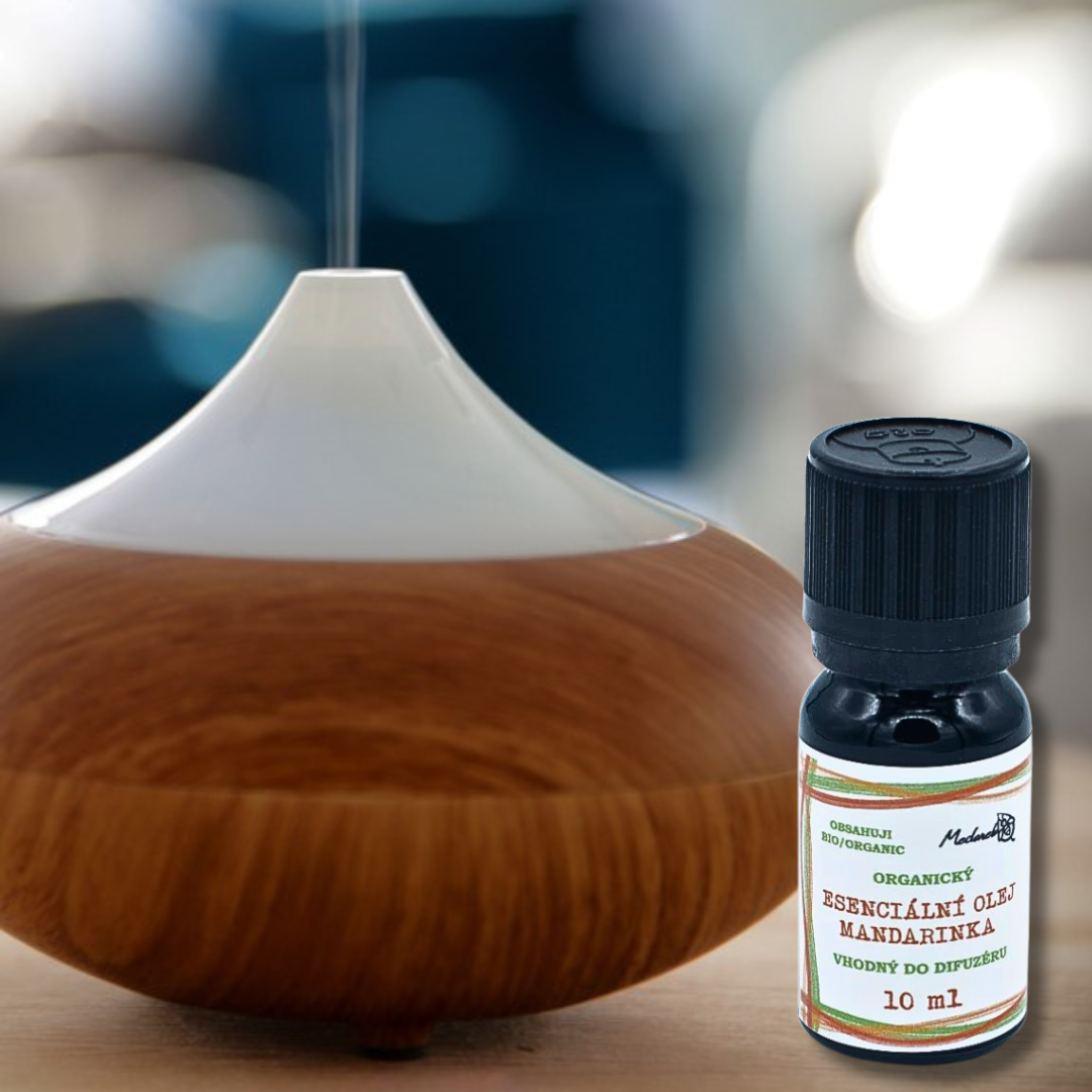 Medarek organic Mandarin essential oil (10 ml, child-safe cap) next to a wood-grain ultrasonic diffuser releasing mist.